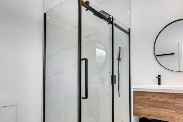 Salle de bain moderne avec douche vitrée.