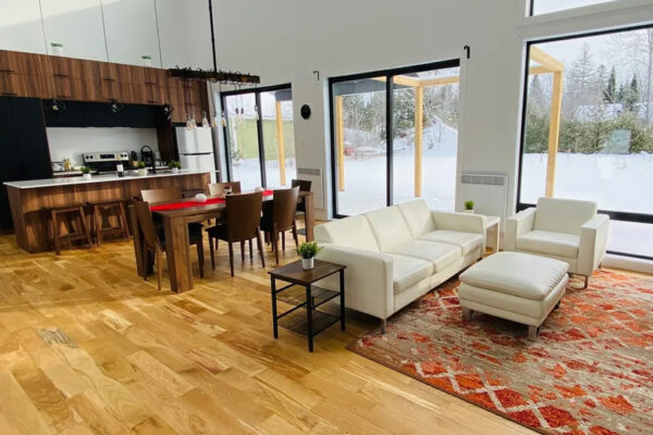 Salon moderne avec cuisine ouverte et vue neige.