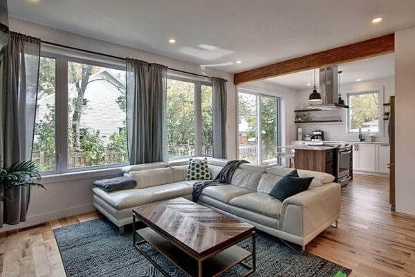 Salon moderne avec canapé et cuisine ouverte.