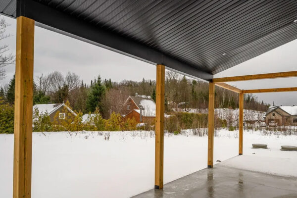 Vue d'une terrasse enneigée avec maisons environnantes.