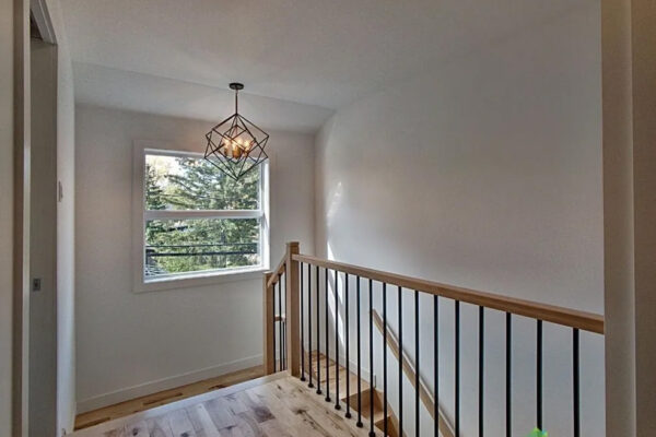 Escalier intérieur avec fenêtre lumineuse.