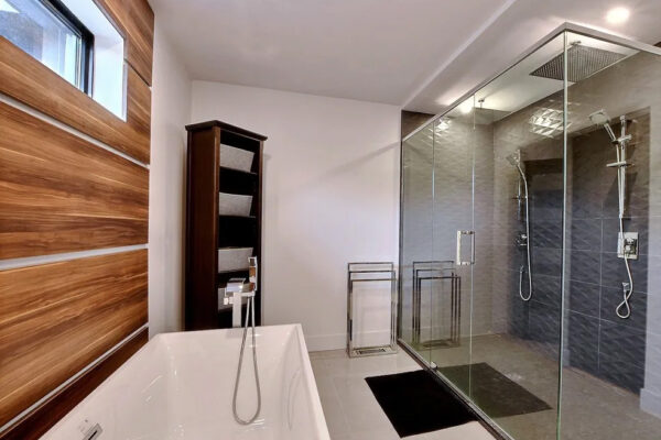 Salle de bain moderne avec douche en verre.