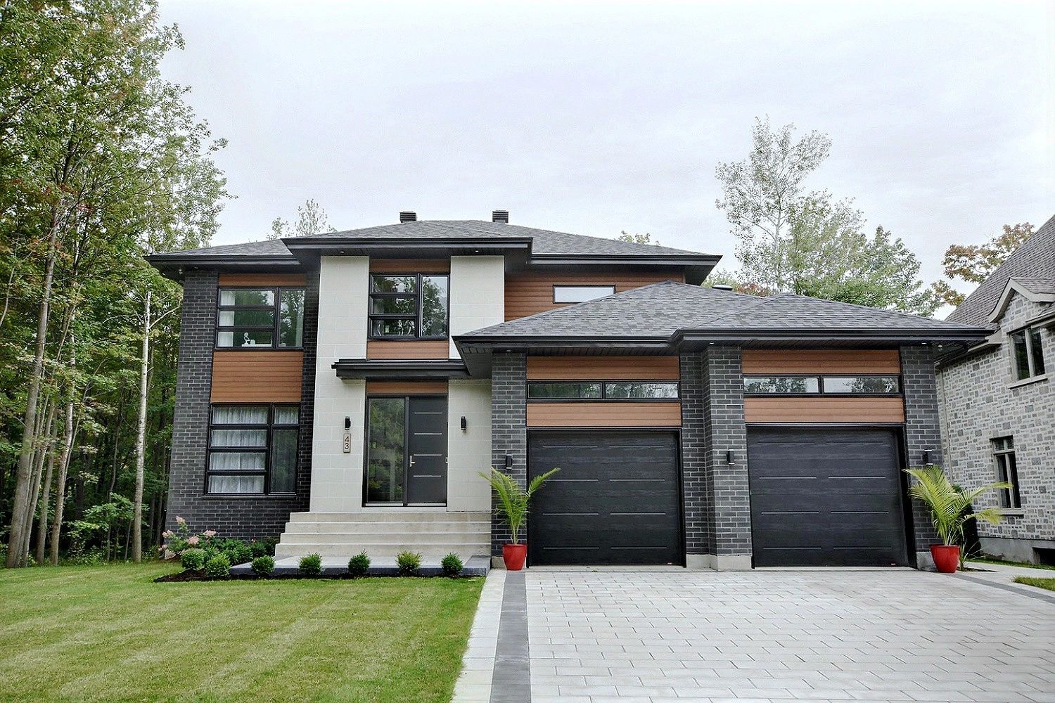 Maison moderne avec garage et jardin verdoyant.